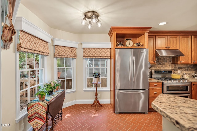 11 Bridgeport Dr, Durham, NC 27713 - kitchen with brown cabinets, brick floor, stainless steel appliances, tasteful backsplash, and under cabinet range hood