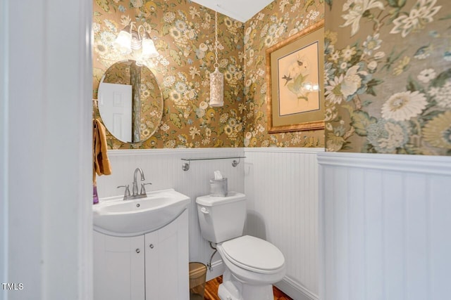 11 Bridgeport Dr, Durham, NC 27713 - bathroom featuring vanity, wainscoting, wood finished floors, toilet, and wallpapered walls