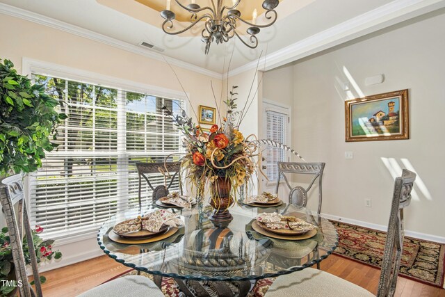 dining space with visible vents, crown molding, wood finished floors, baseboards, and a chandelier
