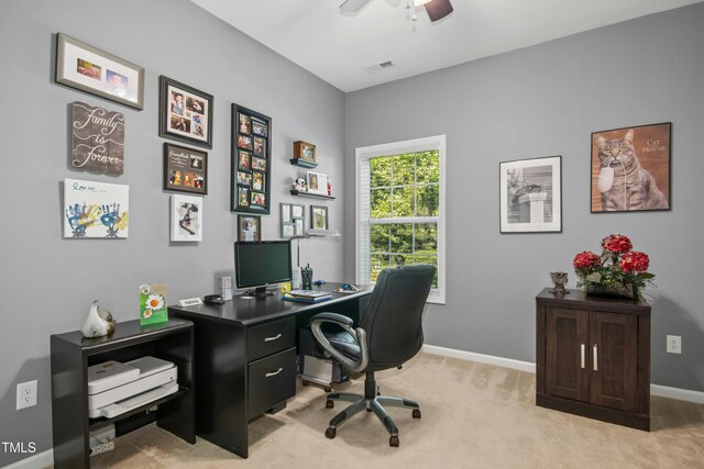 home office featuring a ceiling fan, baseboards, visible vents, and light carpet