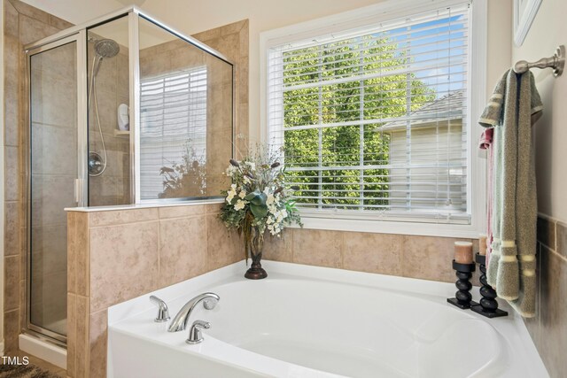 full bathroom featuring a shower stall and a garden tub