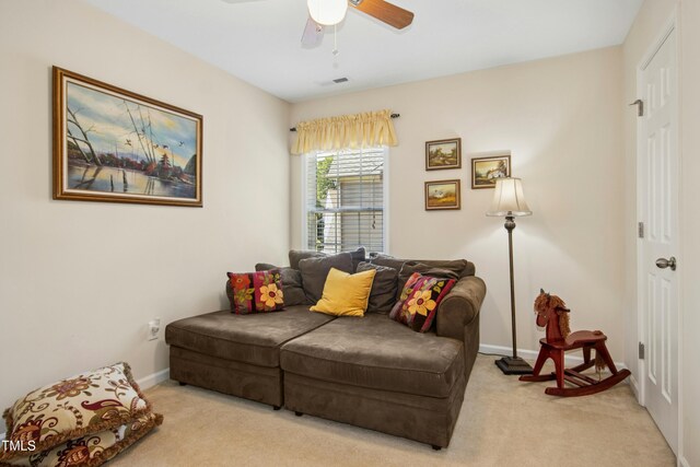 living area featuring light colored carpet, ceiling fan, visible vents, and baseboards