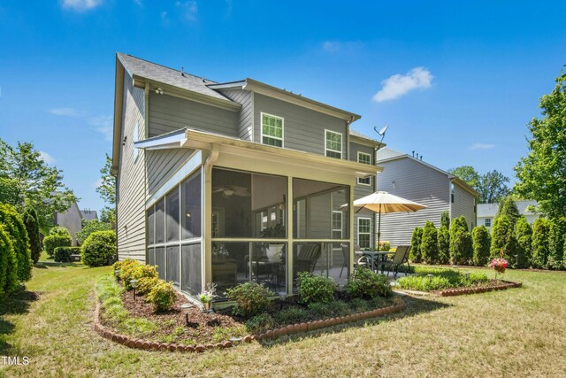 back of property with a lawn and a sunroom