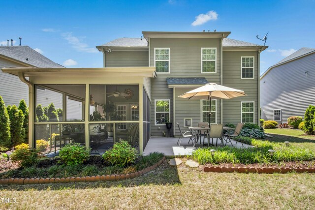 rear view of property featuring a yard, a patio area, and a sunroom