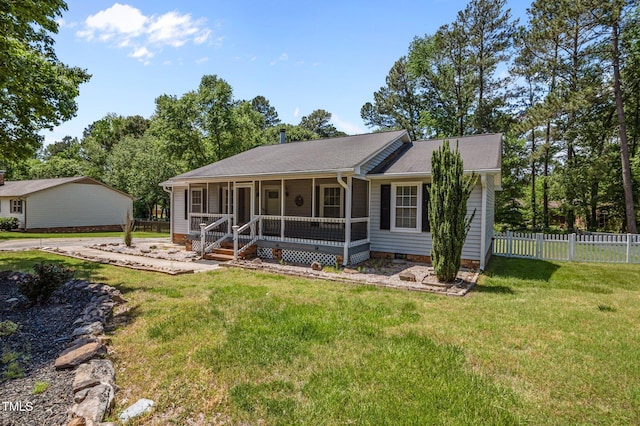 ranch-style home with fence, a shingled roof, and a front lawn