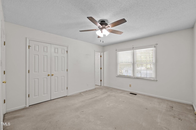 unfurnished bedroom with carpet floors, baseboards, visible vents, and a closet