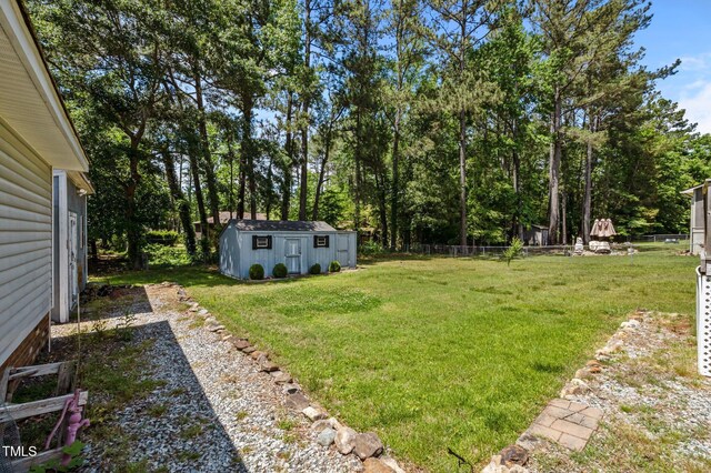 view of yard with fence and an outdoor structure