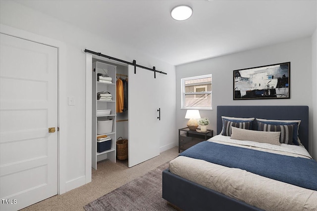 2904 Sprucewood Dr, Durham, NC 27707 - carpeted bedroom with a closet, a barn door, baseboards, and a spacious closet