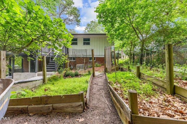 2904 Sprucewood Dr, Durham, NC 27707 - rear view of house with stairs, board and batten siding, and a vegetable garden