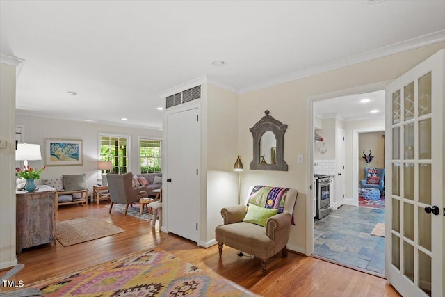sitting room featuring ornamental molding, recessed lighting, and wood finished floors