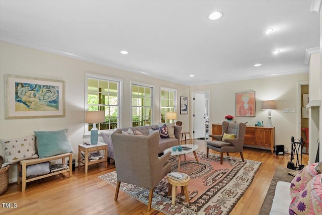 living room with crown molding, recessed lighting, and light wood-style floors
