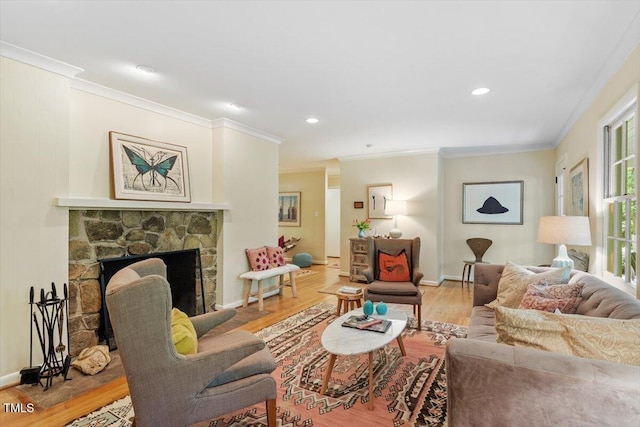 living area featuring baseboards, ornamental molding, a fireplace, and wood finished floors
