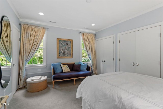 bedroom with carpet floors, ornamental molding, multiple windows, and visible vents