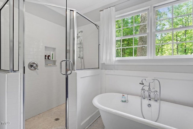 full bathroom featuring tile patterned flooring, a freestanding bath, a healthy amount of sunlight, and a shower stall