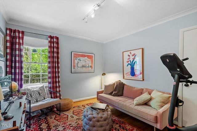 living room featuring baseboards, ornamental molding, track lighting, and wood finished floors