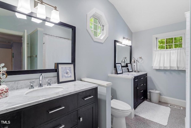 bathroom featuring vaulted ceiling, two vanities, a sink, tile patterned floors, and toilet