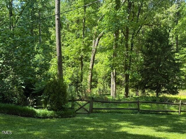 view of yard featuring a view of trees and fence