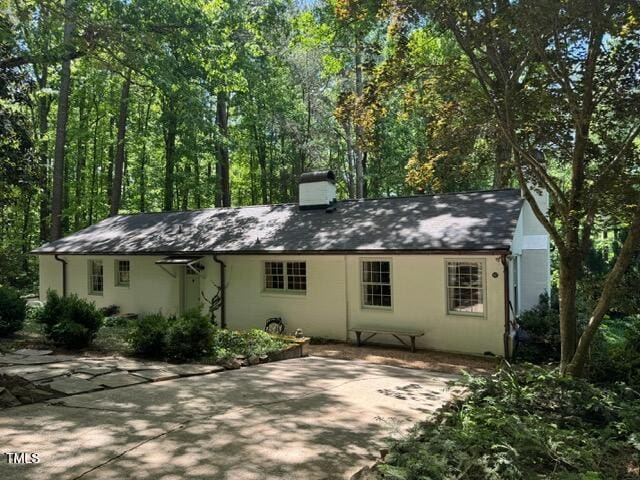 rear view of house featuring a chimney