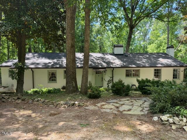 view of front of home with a chimney and stucco siding