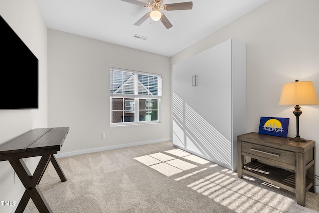 interior space with visible vents, baseboards, carpet floors, and ceiling fan
