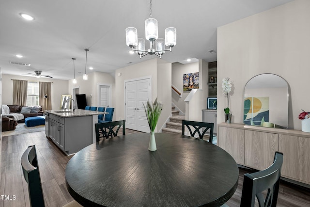 dining room featuring visible vents, stairs, ceiling fan with notable chandelier, recessed lighting, and dark wood-type flooring