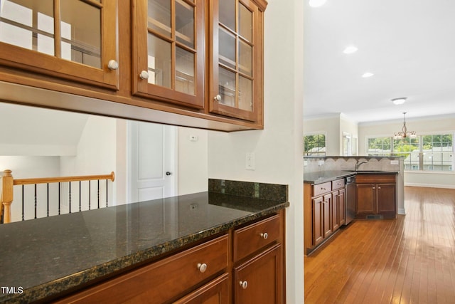 bar featuring stainless steel dishwasher, a sink, a chandelier, recessed lighting, and light wood-style flooring