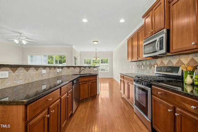 kitchen featuring crown molding, backsplash, stainless steel appliances, and brown cabinetry
