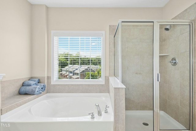 full bathroom featuring a bath and a shower stall