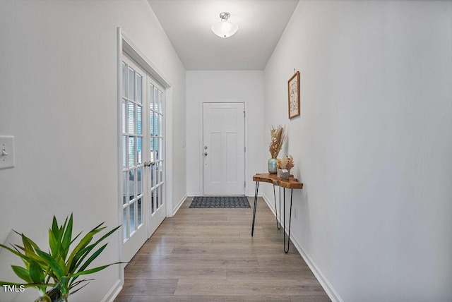 entryway featuring wood finished floors, french doors, and baseboards