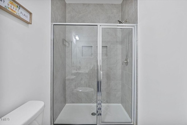 full bath with toilet and a stall shower