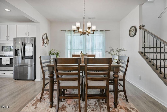 dining space with a chandelier, light wood-type flooring, stairs, baseboards, and recessed lighting