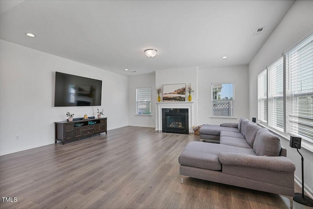 living area featuring wood finished floors, a fireplace with flush hearth, recessed lighting, and baseboards