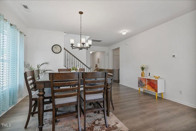 dining area featuring a chandelier, dark wood-style flooring, and baseboards
