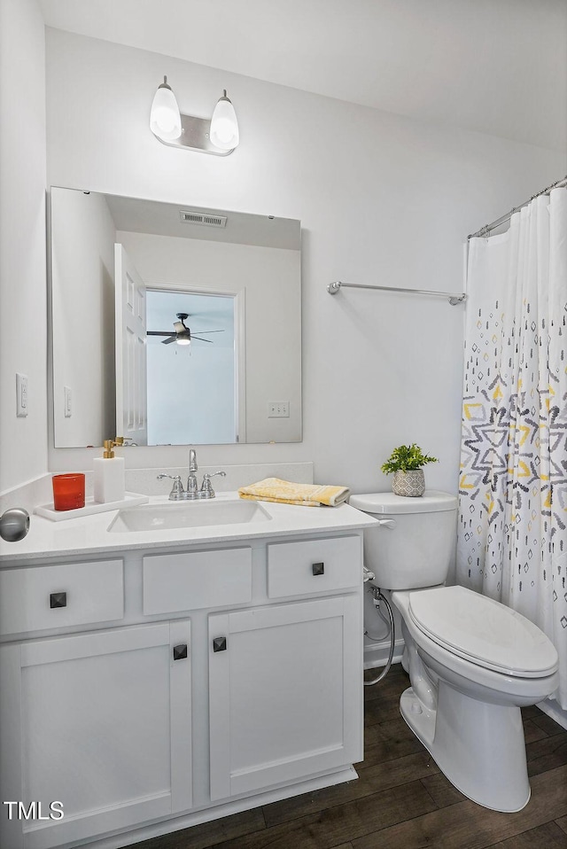 bathroom featuring toilet, wood finished floors, vanity, a ceiling fan, and a shower with curtain