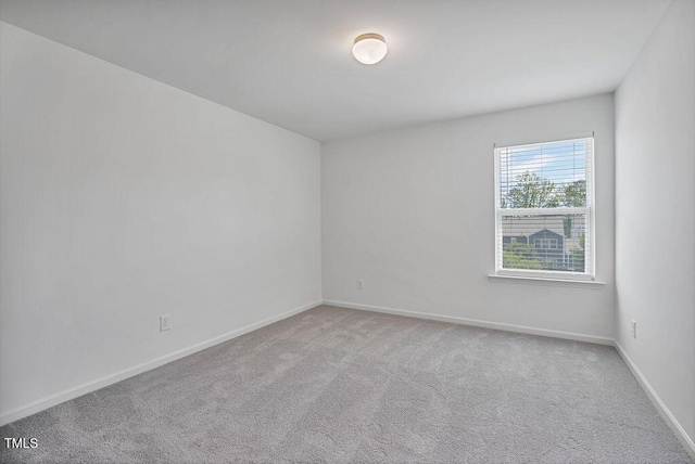 spare room featuring carpet floors and baseboards