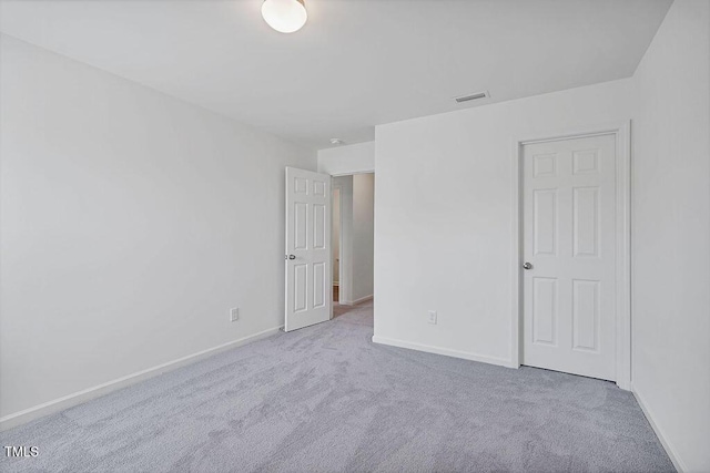 carpeted spare room featuring baseboards