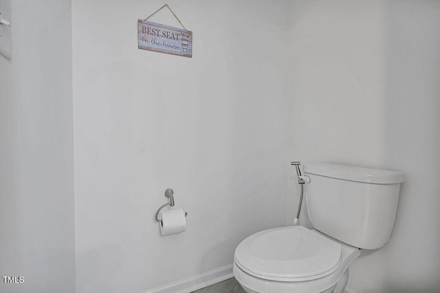 bathroom with toilet and baseboards