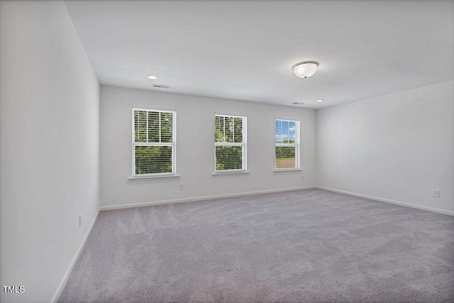 spare room featuring carpet and baseboards