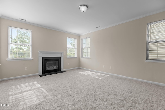 unfurnished living room with crown molding, baseboards, a healthy amount of sunlight, and visible vents