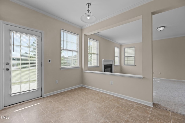 unfurnished dining area featuring crown molding, baseboards, and a glass covered fireplace