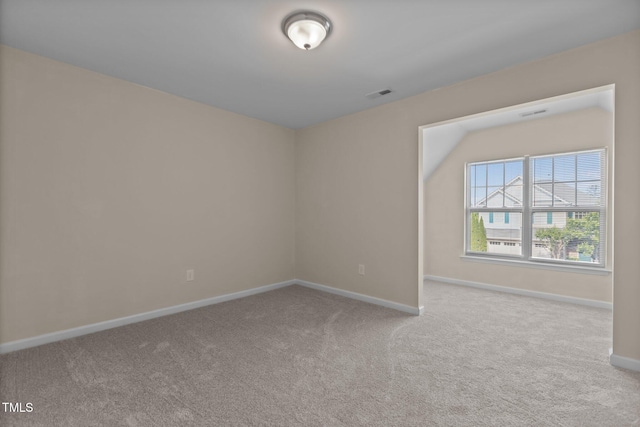 carpeted spare room with visible vents and baseboards