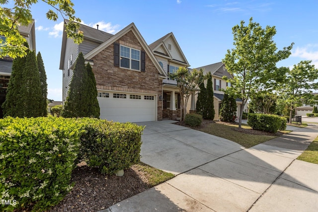 view of front of property with concrete driveway, stone siding, and a garage