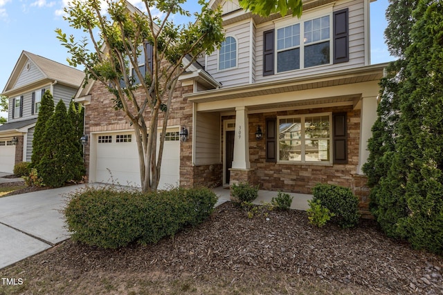 view of front of property featuring a garage, driveway, covered porch, and stone siding