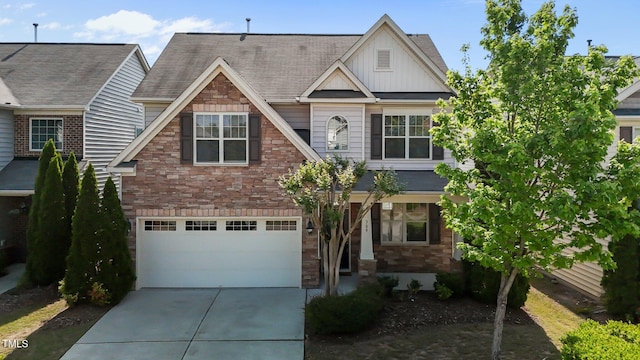craftsman-style home with concrete driveway, an attached garage, board and batten siding, and stone siding