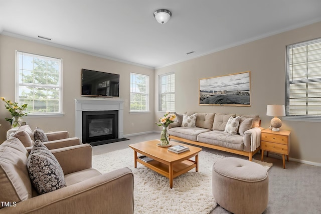 living room with a fireplace with flush hearth, a healthy amount of sunlight, ornamental molding, and visible vents