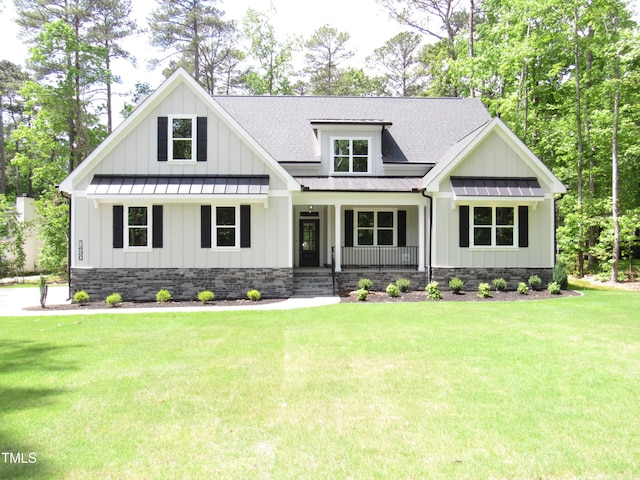 modern inspired farmhouse featuring a front yard, a standing seam roof, a shingled roof, board and batten siding, and a porch