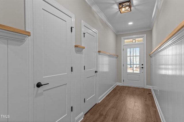 doorway to outside featuring baseboards, ornamental molding, recessed lighting, and wood finished floors