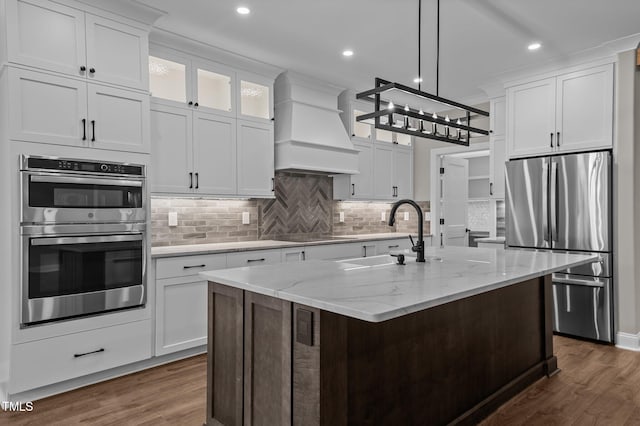 kitchen featuring a sink, stainless steel appliances, custom exhaust hood, and dark wood finished floors