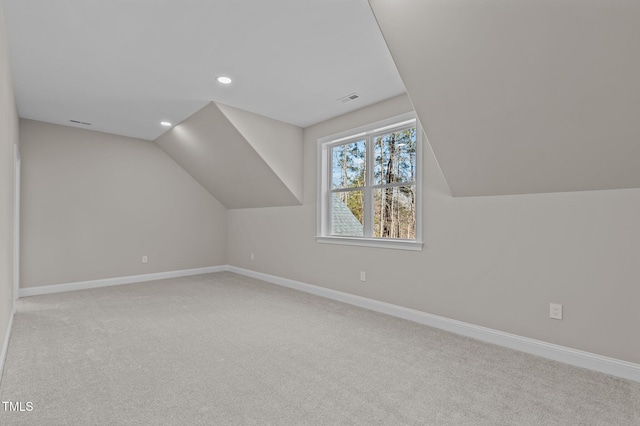 additional living space featuring visible vents, baseboards, carpet, and lofted ceiling