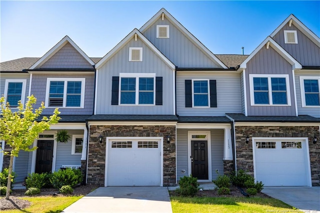 view of front of home with a garage, board and batten siding, stone siding, and concrete driveway